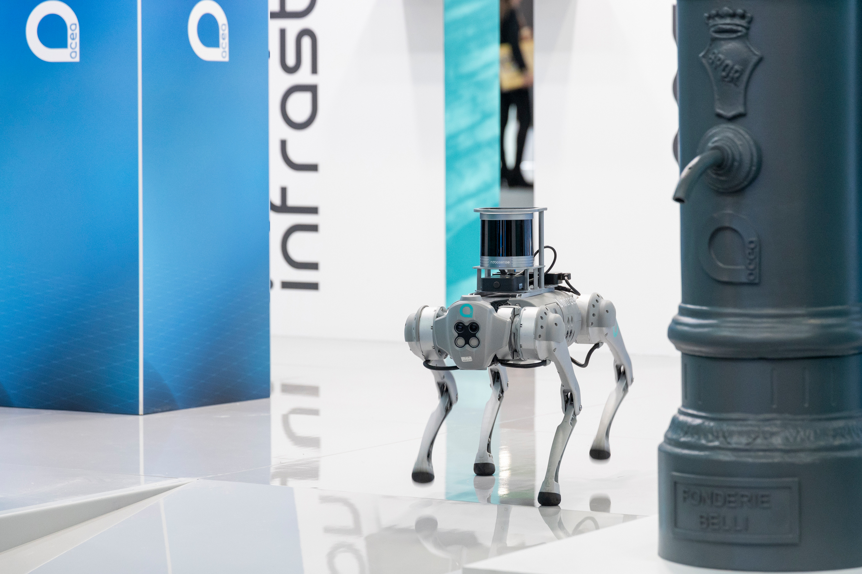 Close-up of the dog-shaped Acea Robot, next to a water fountain