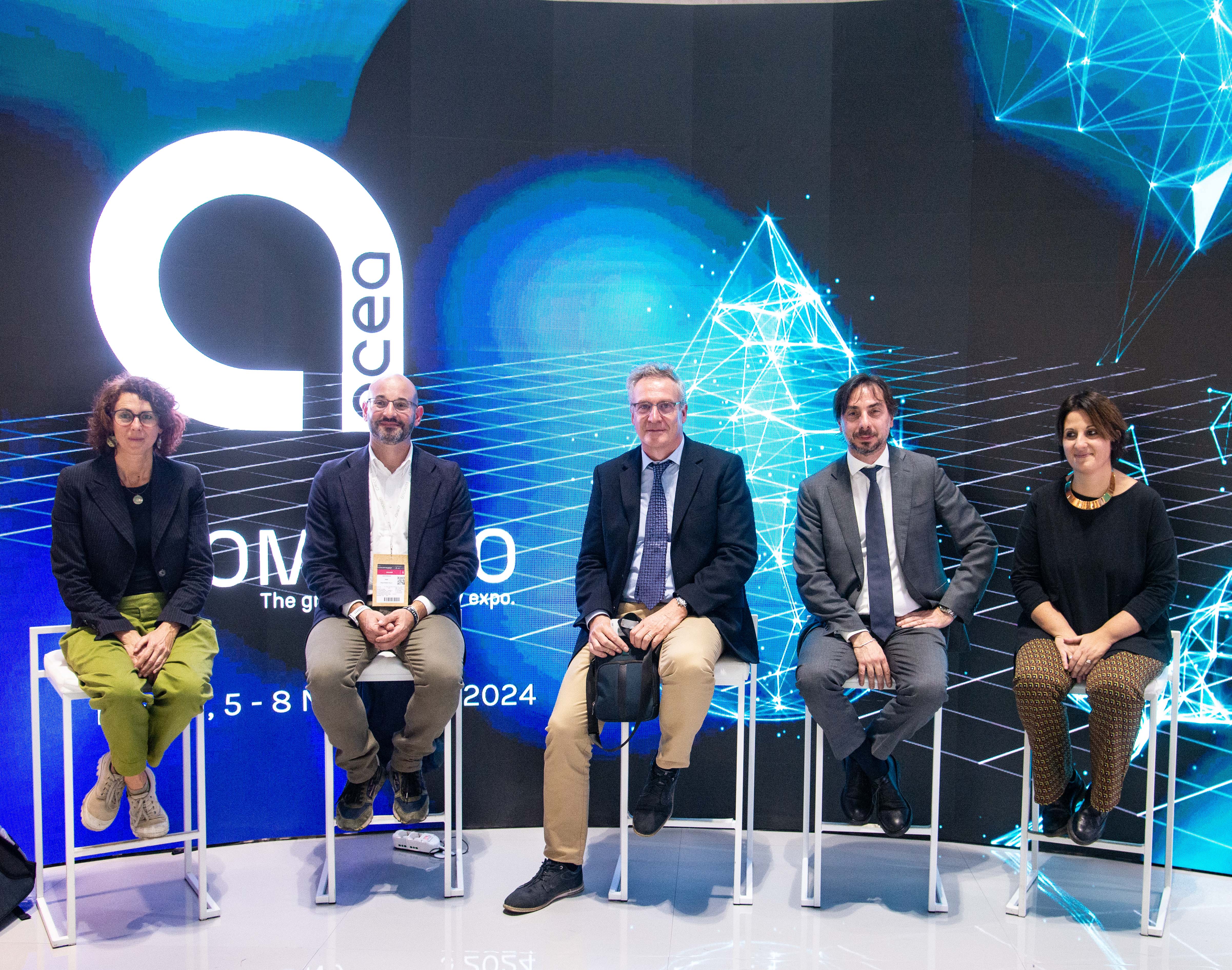 Five conference speakers sitting on stools, they have the acea logo behind them