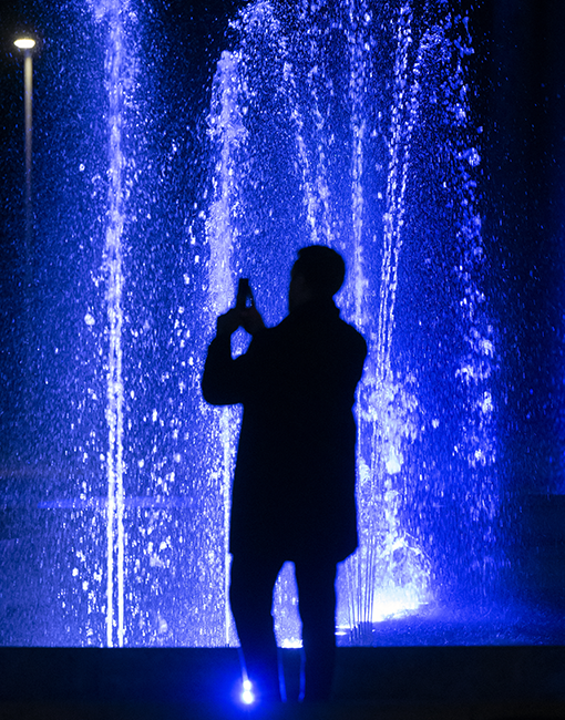 A man, seen from behind, takes a photo during the event celebrating Acea's 115th anniversary