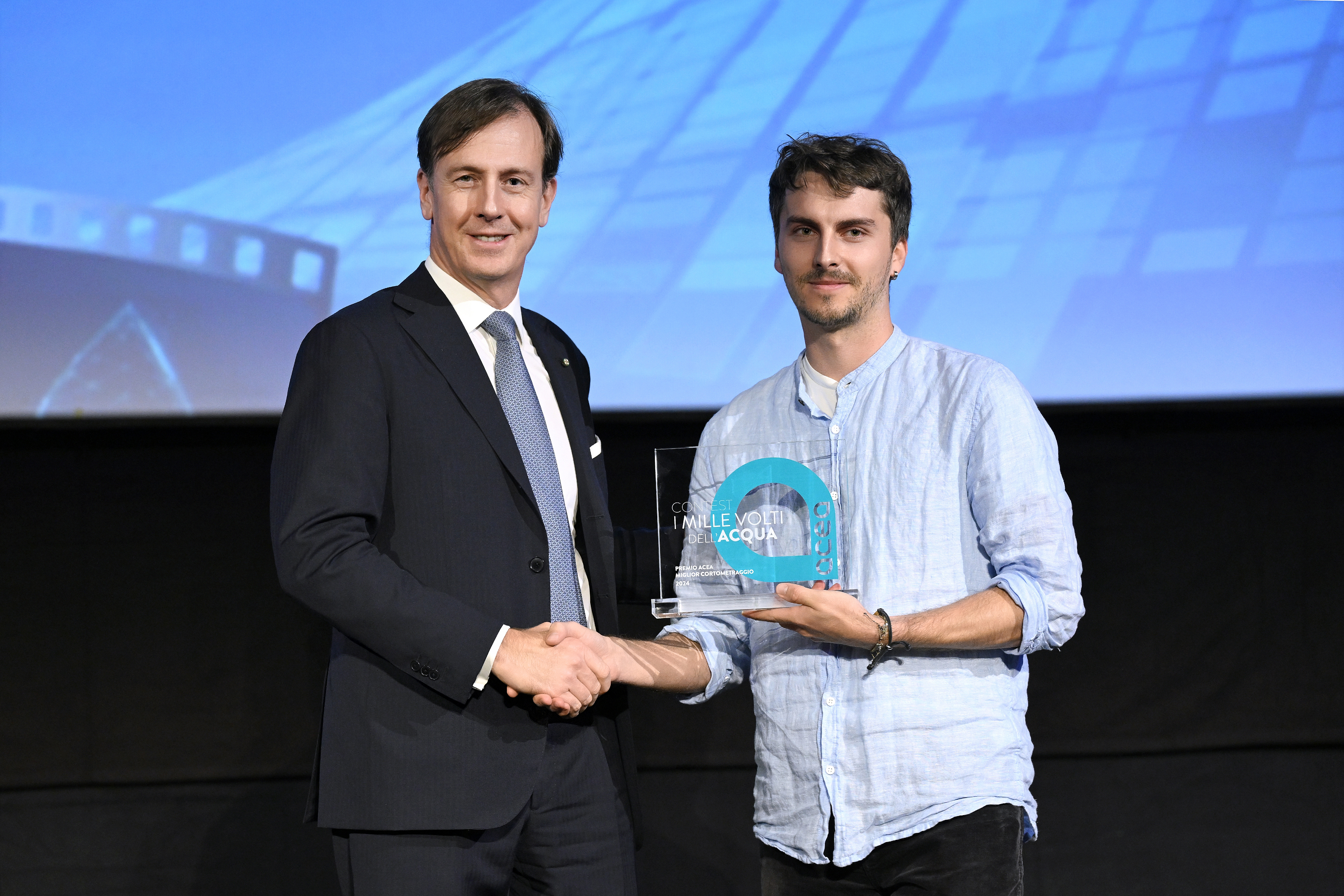 Managing Director Fabrizio Palermo shakes hands with one of the winners of the Thousand Faces of Water contest