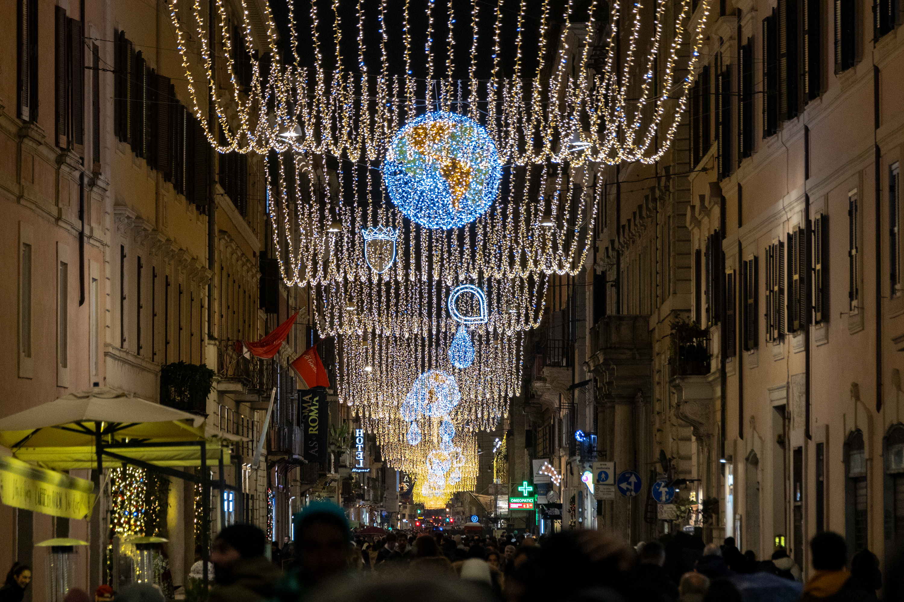 Vista in prospettiva delle luminarie di via del corso con in primo piano la luminaria del mappamondo