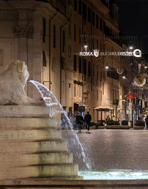 fontana di piazza del popolo con l'inizio di via del corso illuminato