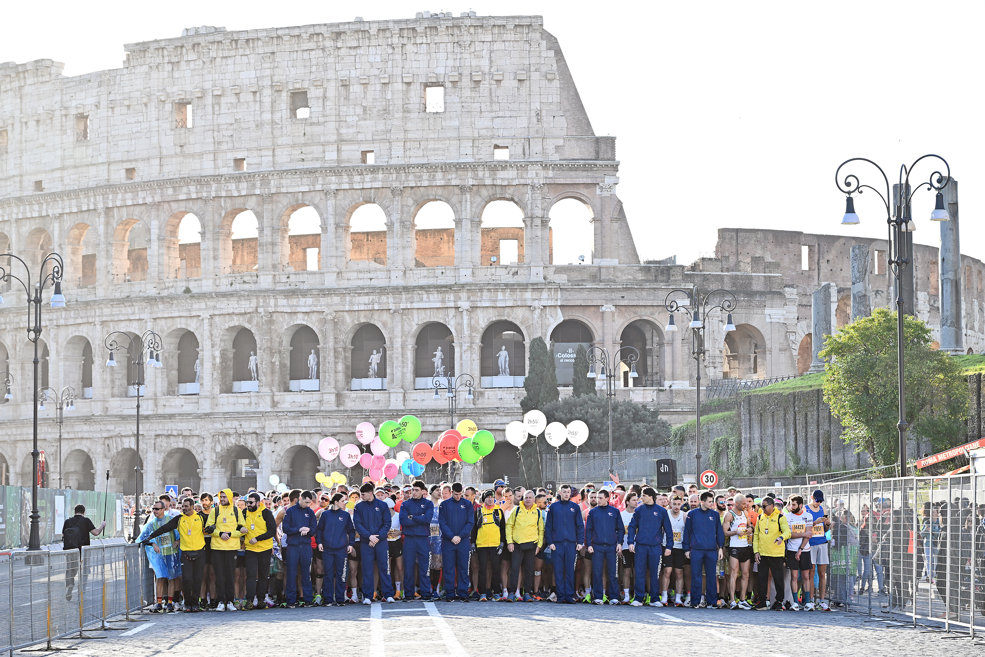 Some of the matathon participants gathered for a photo with the colosseum behind them. Some of them hold colourful balloons