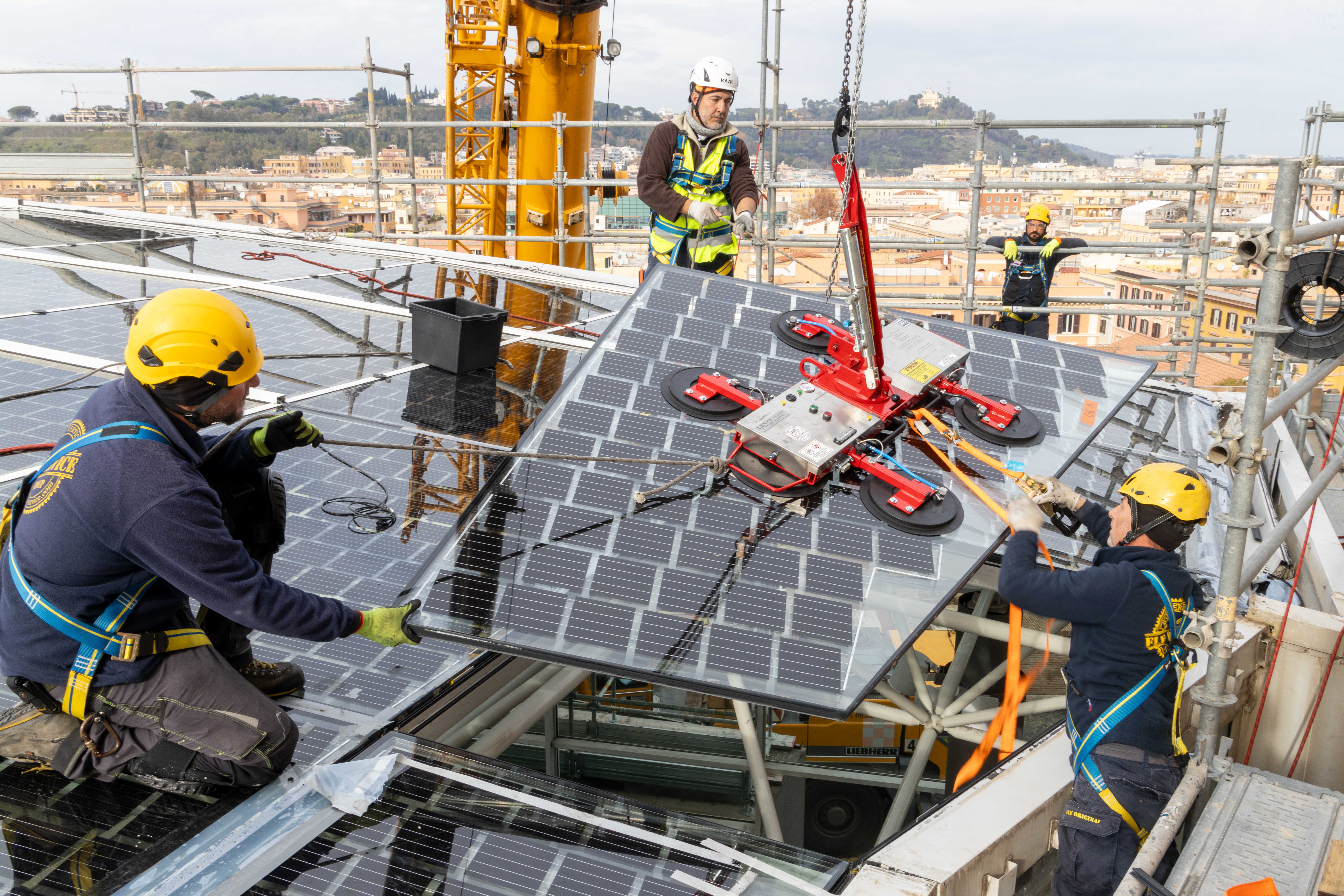3 operai con dispositivi di protezione mentre stanno installando un pannello fotovoltaico